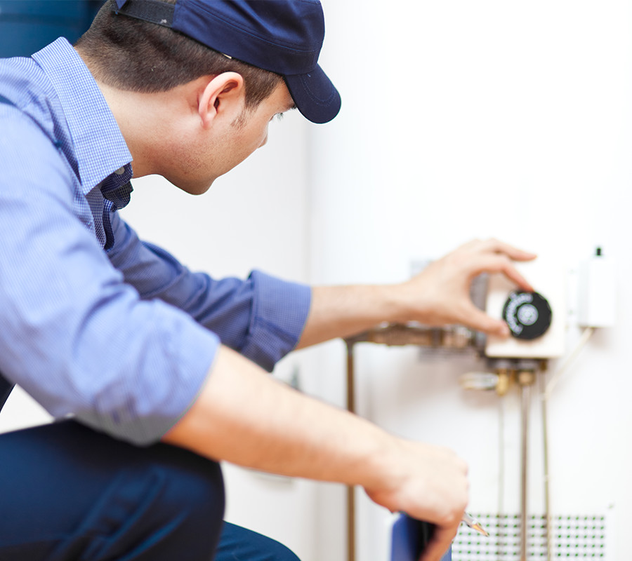 A man working on a water heater.